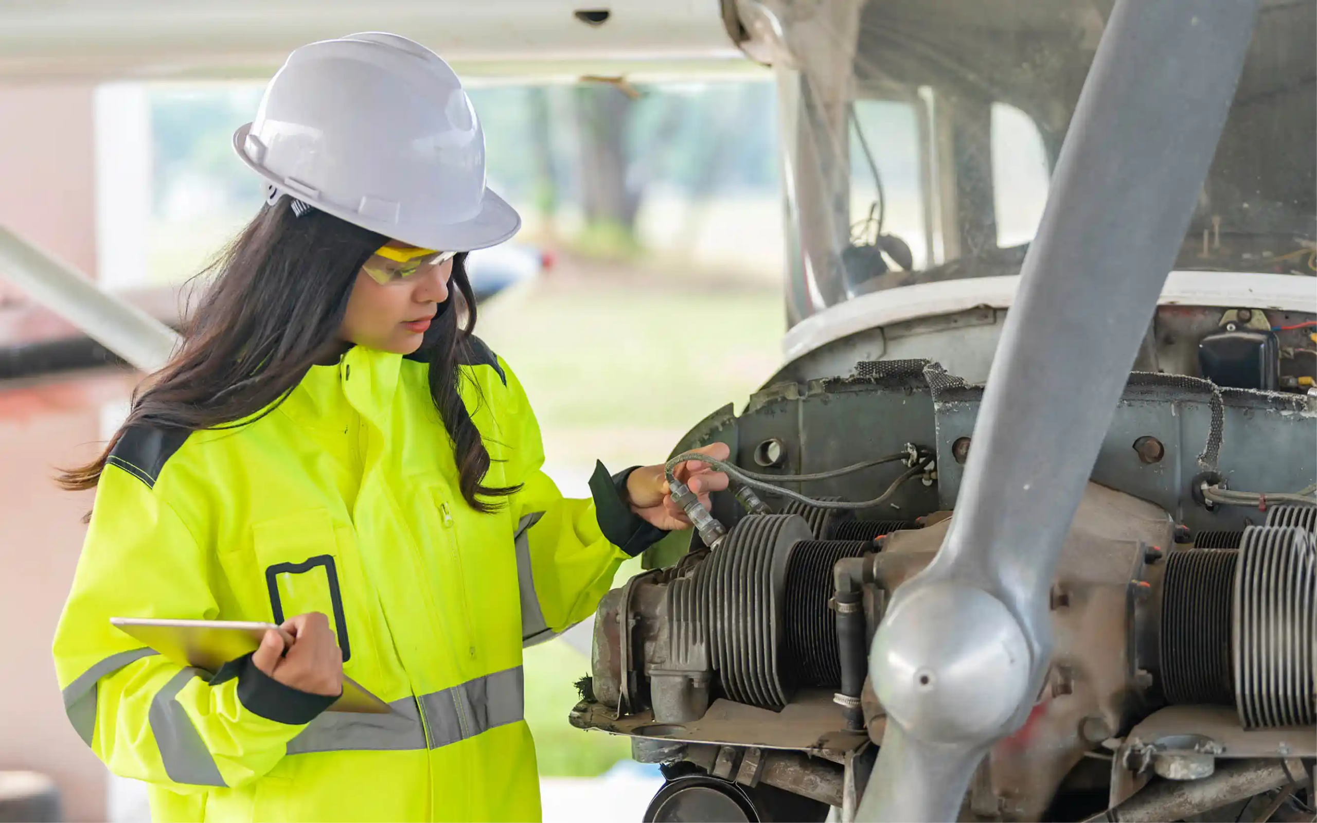 diverse female mechanic working on a plane