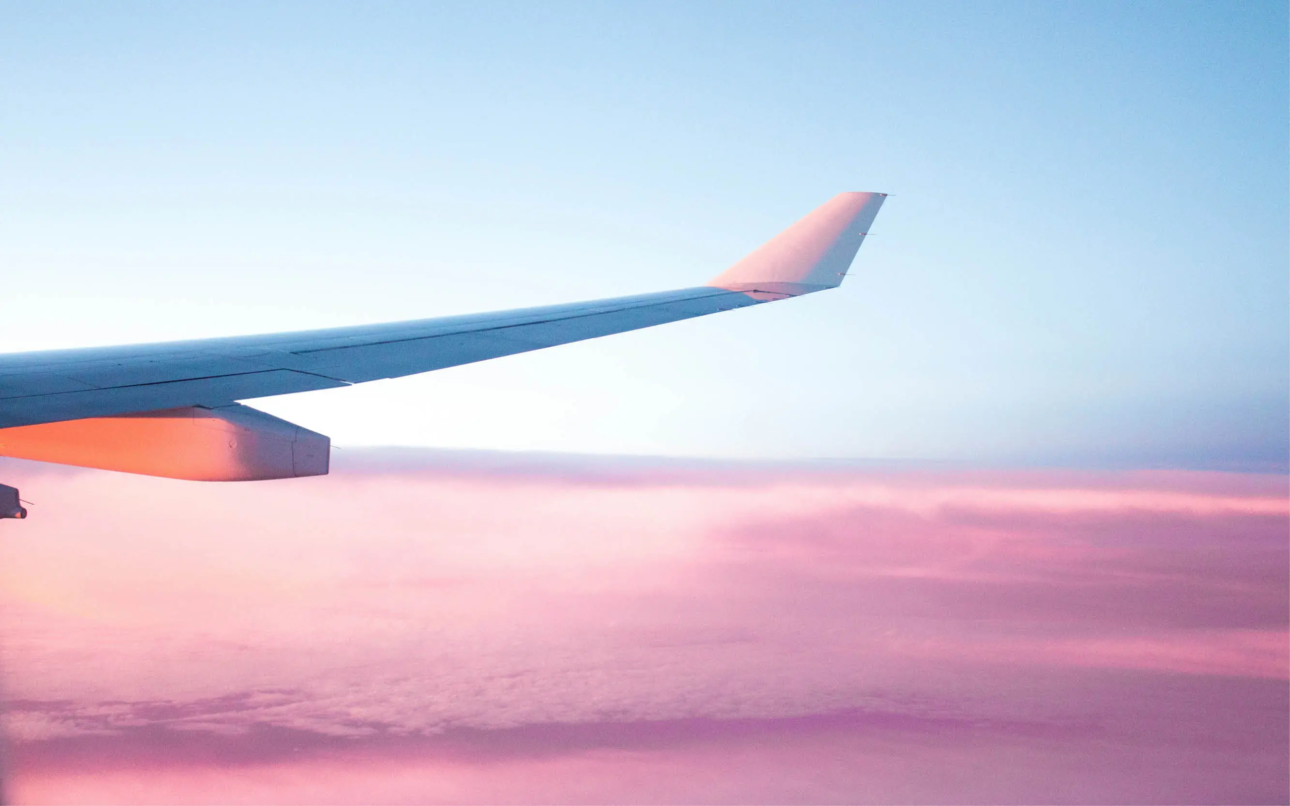 airplane wing over pink clouds